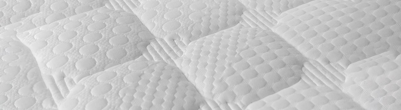 Zoom na superfície de colchão branco com costuras.