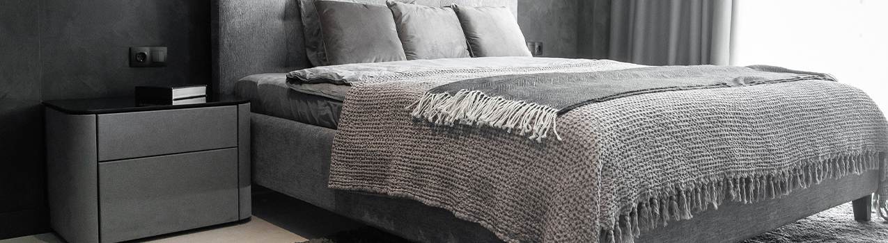 Imagem de quarto com decoração na cor cinza. Ao centro, modelo de colchão com base cama box casal.